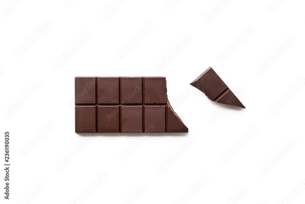 Broken dark chocolate bar isolated on white table. Horizontal composition. Top view Broken dark chocolate bar isolated on white table. Horizontal composition. Top view