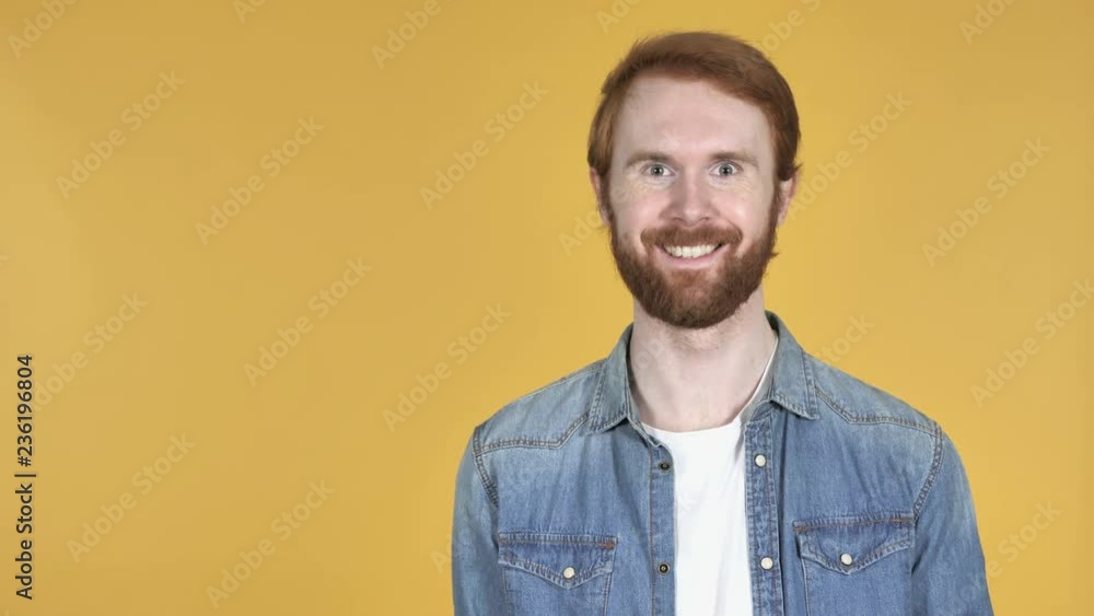 Redhead Man Pointing with Finger on Side, Yellow Background Redhead Man Pointing with Finger on Side, Yellow Background