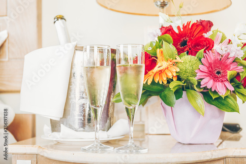 Two glasses of champagne in the upscale hotel room. Dating, romance, honeymoon, valentine, getaway concepts