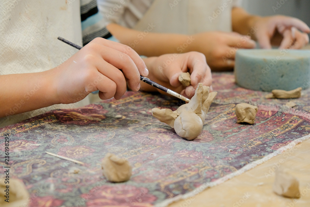 A child molds a product from clay in a modeling lesson. A child molds a product from clay in a modeling lesson.