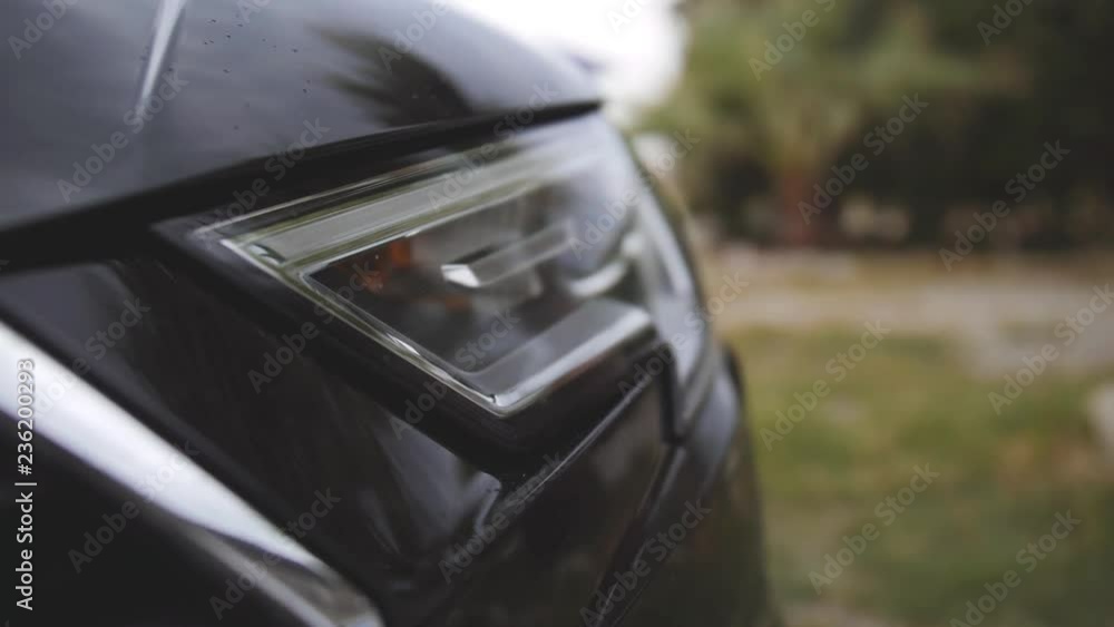 Headlight of modern black car. Detailed view on lighting gear. Close up shot Headlight of modern black car. Detailed view on lighting gear. Close up shot