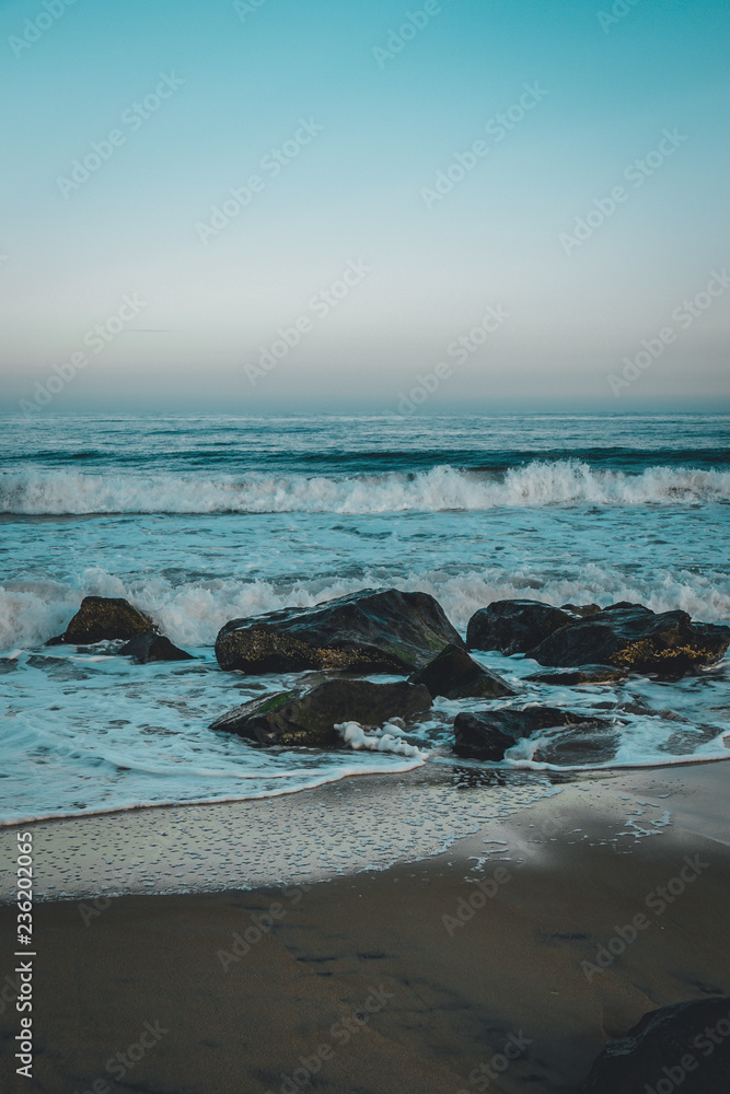 Waves on a beach with rocks