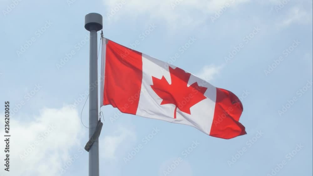 Canadian flag blowing in the wind. Clouds moving behind. Canadian flag blowing in the wind. Clouds moving behind.