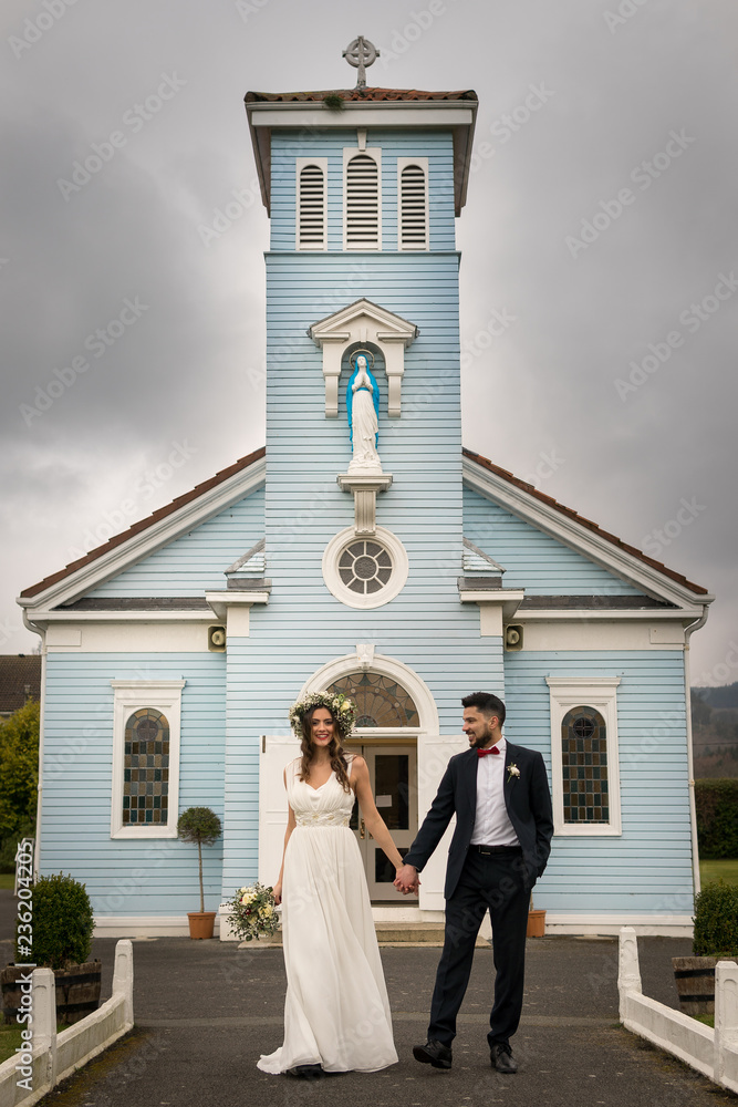 young couple bride groom getting married wedding posed photos at seaside sea beach hairpiece flowers bouquet church