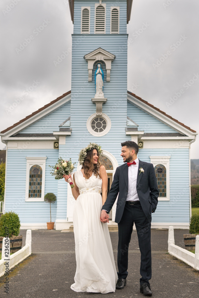 young couple bride groom getting married wedding posed photos at seaside sea beach hairpiece flowers bouquet church