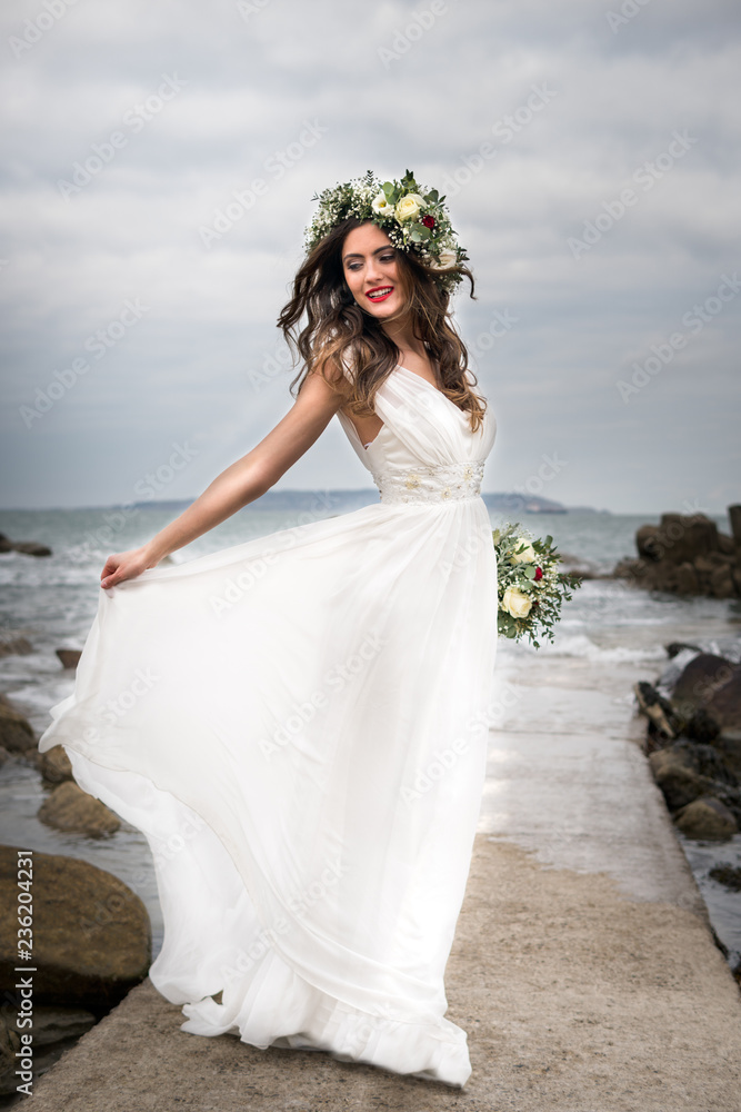 young bride getting married wedding posed photos at seaside sea garden beach hairpiece flowers bouquet