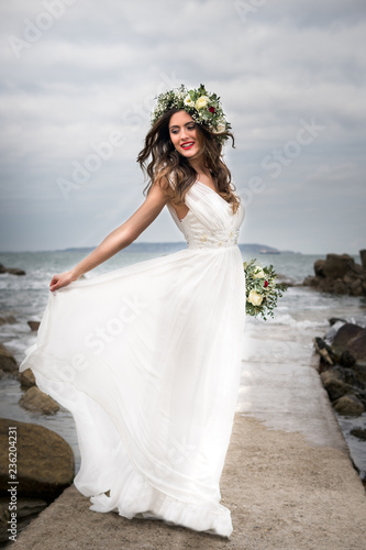 Obraz na płótnie young bride getting married wedding posed photos at seaside sea garden beach hairpiece flowers bouquet w salonie