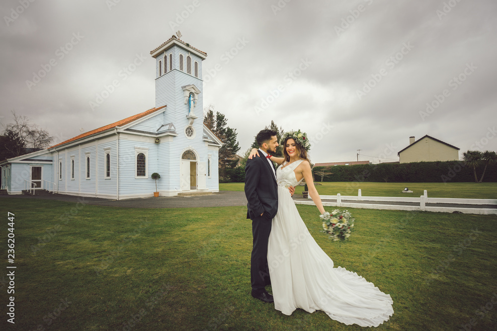 young couple bride groom getting married wedding posed photos at seaside sea beach hairpiece flowers bouquet church