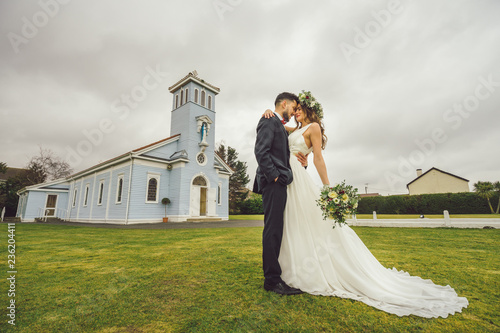 young couple bride groom getting married wedding posed photos at seaside sea beach hairpiece flowers bouquet church