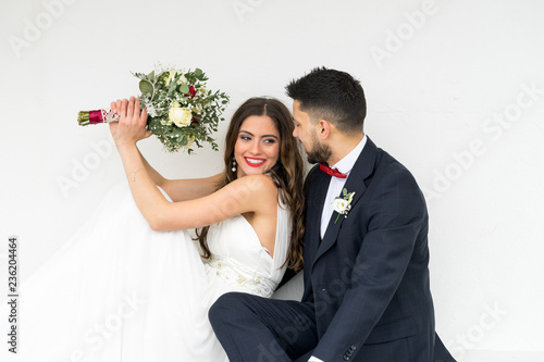 Obraz na płótnie young couple bride groom getting married wedding posed photos at seaside sea beach hairpiece flowers bouquet church w salonie