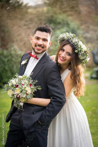 Obraz na płótnie young couple bride groom getting married wedding posed photos at seaside sea beach hairpiece flowers bouquet church w salonie