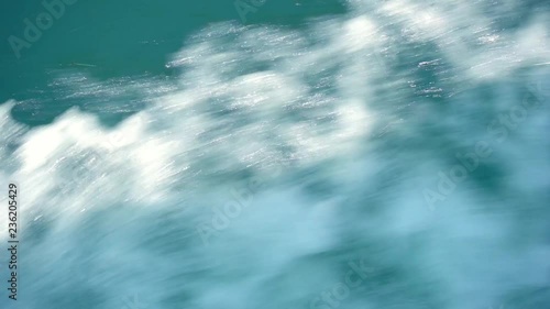 A slow motion view of the wake behind a large cruise ship at sea.
