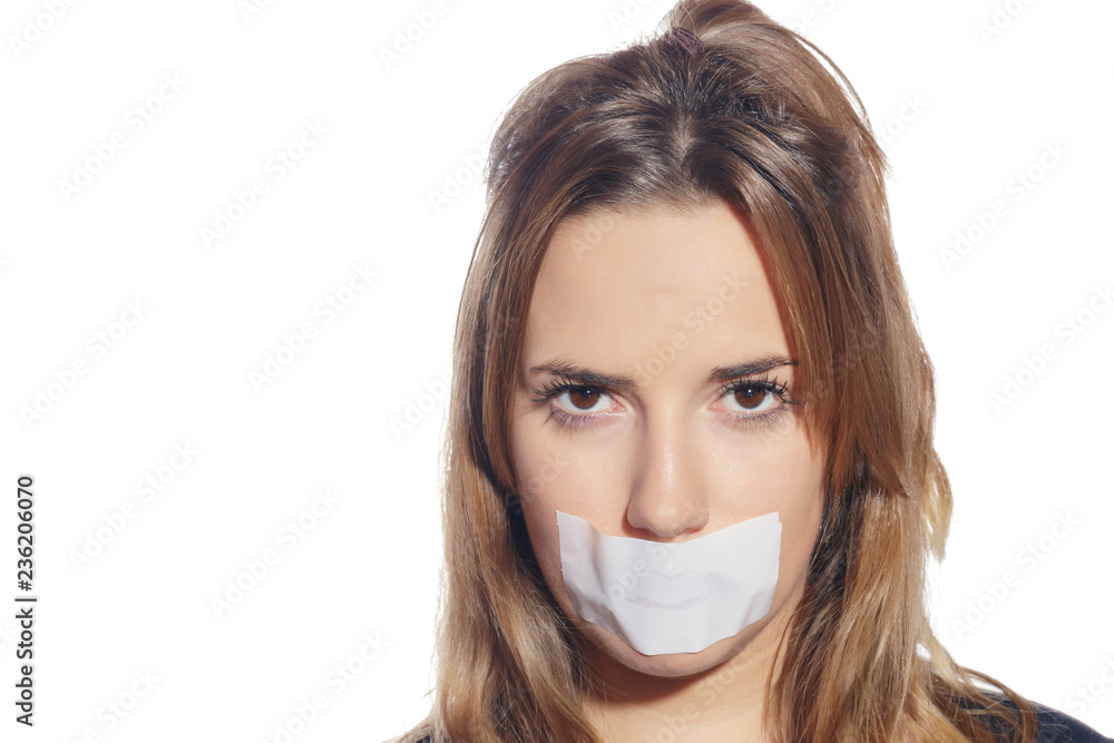 Blonde woman silenced with tape, removing it and finally free. Isolated, over a white background. Blonde woman silenced with tape, removing it and finally free. Isolated, over a white background.