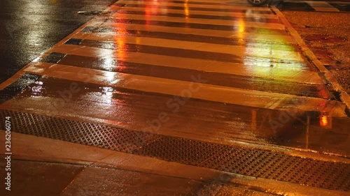 Crosswalk lines painted on road with traffic. Rainy, summer night on Danforth Avenue, Toronto, Ontario, Canada. photo
