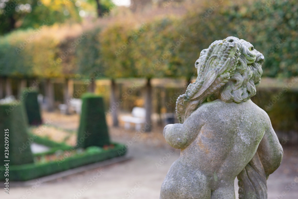 Obraz premium Stone angel statue in garden. Guardian angel statue in sunlight as a symbol of love in garden.