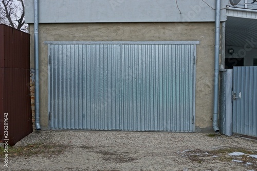 facade of a private garage with gray metal gates in the street © butus