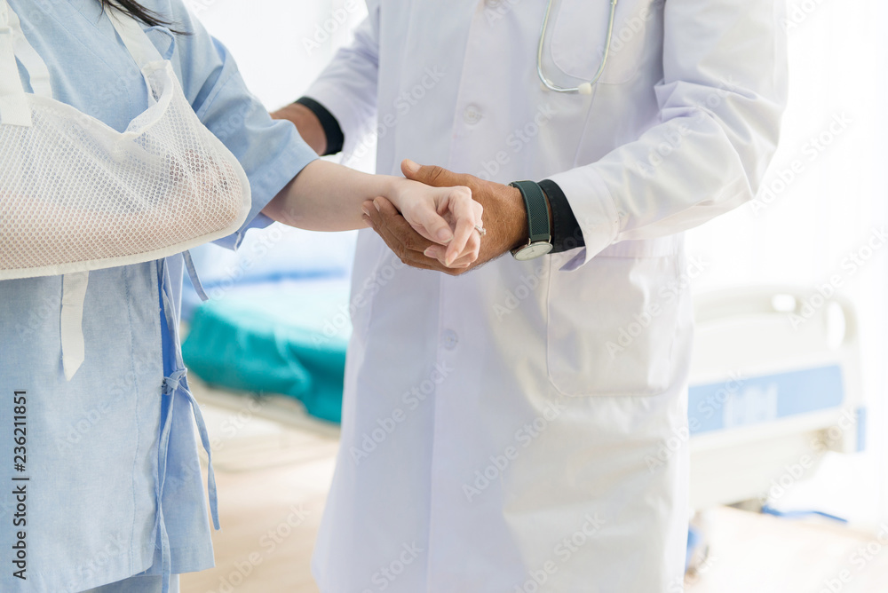 Female patient with arm splint and doctor support to her at hospital,Holding hand Female patient with arm splint and doctor support to her at hospital,Holding hand