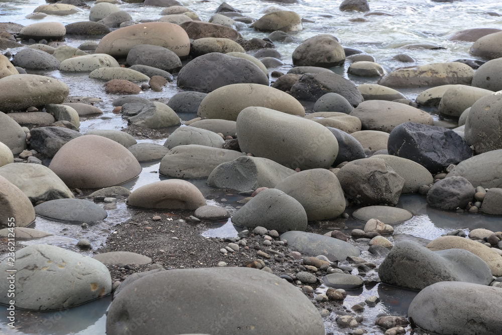 Big smooth black beach stones in the water Big smooth black beach stones in the water