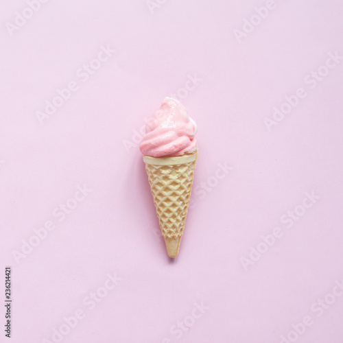 Pink meringue on ice cream cone on pink background