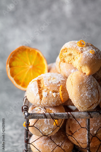 Homemade orange crinkle cookies  in small metal basket on gray background, vertical composition
