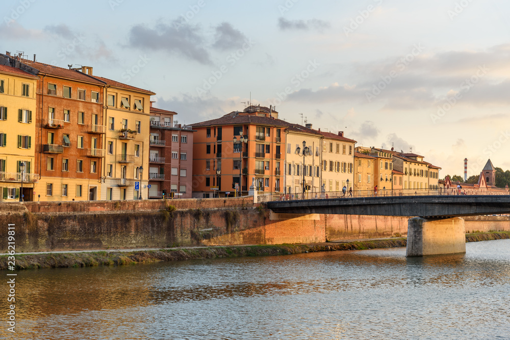 View on embankment of Arno river and Solferino bridge at sunset. Pisa, Italy
