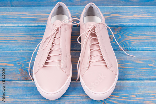 Pair of pink womanly leather shoes on old blue boards