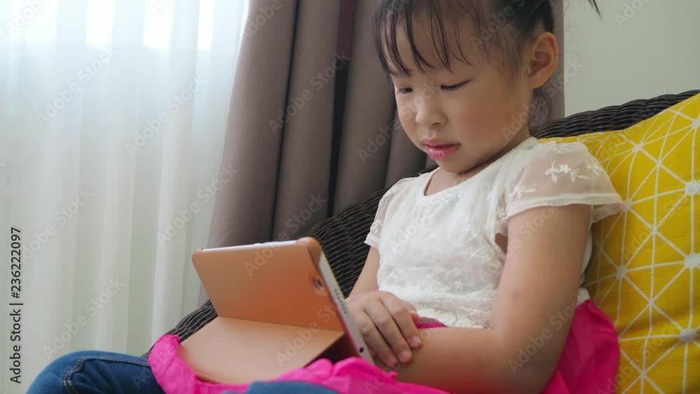 Little asian girl lying on bed ,watching cartoon online via tablet computer at home
Little asian girl lying on bed ,watching cartoon online via tablet computer at home