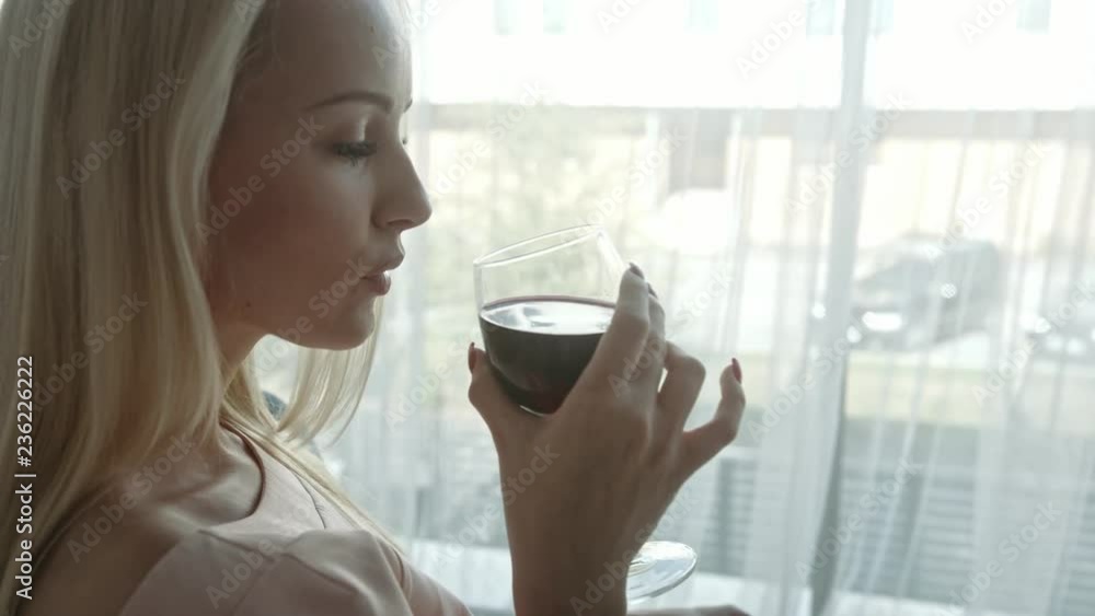 Blond woman reading a novel and drinking wine Blond woman reading a novel and drinking wine