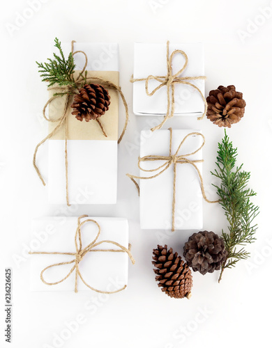 Minimal Christmas and New year flat lay gift box with pine tree and pine cone on white background