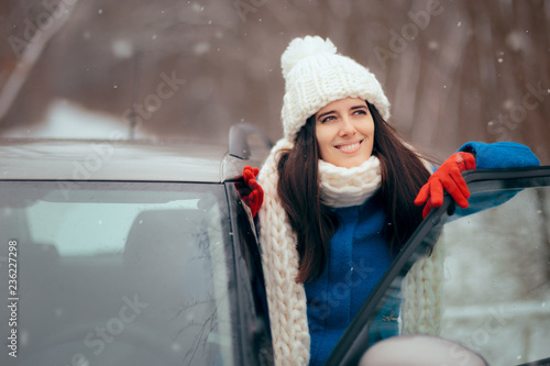 Happy Female Driver Standing By Her Car Admiring the Snow