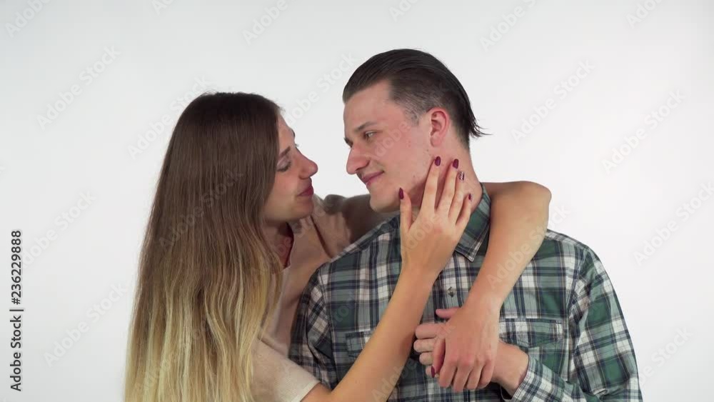 Gorgeous young loving couple hugging, looking at each other with love. Stunning young woman embracing her handsome boyfriend from the back, touching his face gently Gorgeous young loving couple hugging, looking at each other with love. Stunning young woman embracing her handsome boyfriend from the back, touching his face gently