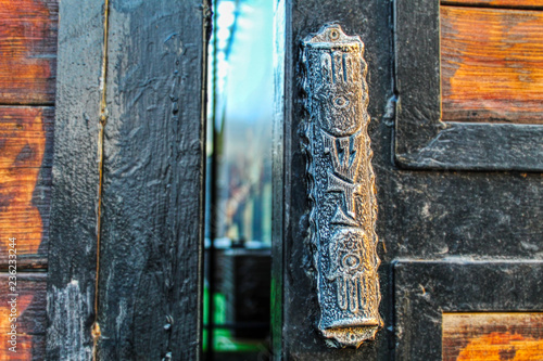 Vintage Mezuzah on old iron gates with wooden inserts. Mezuzah - sign of the Jewish house in Israel and around the world
