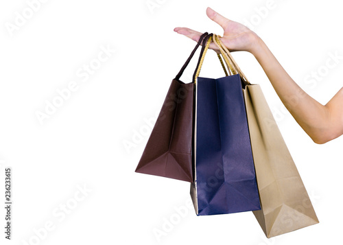 Woman carrying paper shopping bags isolated on white background. Adult woman hand hold three shopping bag with blue and brown color. Customer and shopping bag. Black Friday concept.