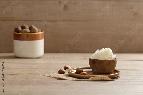 Canvas Print Shea butter and nuts on a wooden board, copy space.