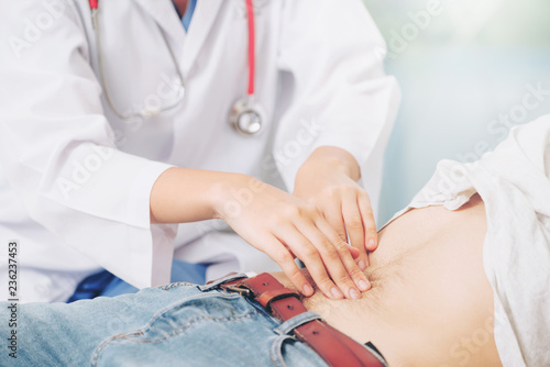 Woman doctor is talking and examining male patient in hospital office. Healthcare and medical service. photo