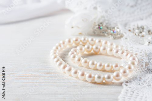 White pearl necklace on handmade lace background.