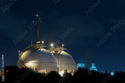 Landscape of oil refinery industry with oil storage tank in night.