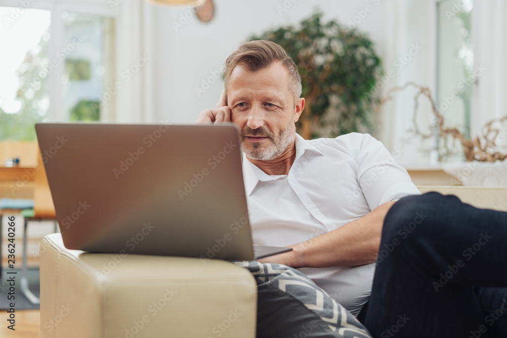 Man relaxing on a large sofa at home