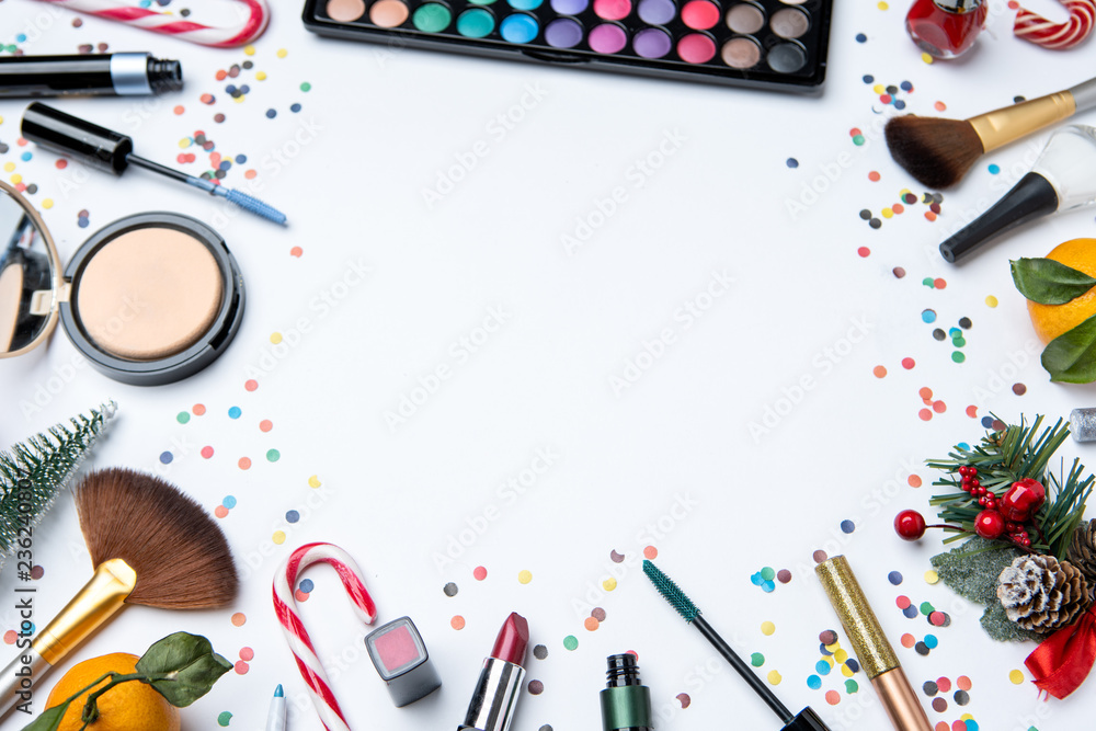 Picture on top of eye shadows, brushes, , tangerine, sugar cane ,nail polish on empty white table Picture on top of eye shadows, brushes, , tangerine, sugar cane ,nail polish on empty white table