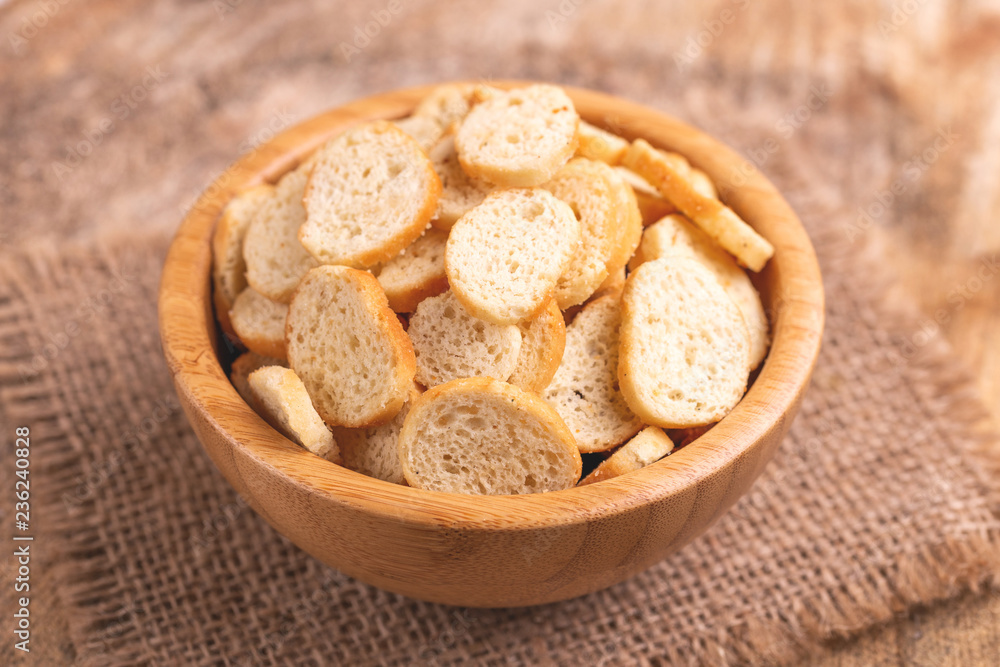 Obraz premium Wheat salted crackers in wooden bowl on burlap napkin