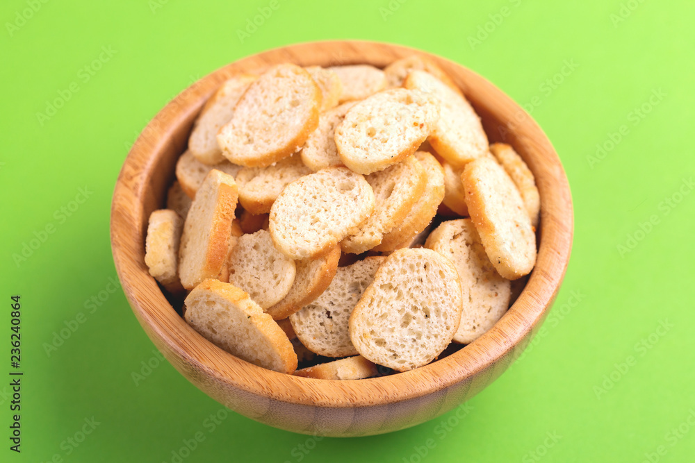 Wheat salted crackers in wooden bowl on bright colored background Wheat salted crackers in wooden bowl on bright colored background