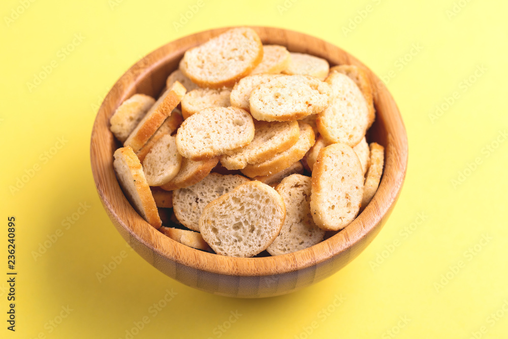 Wheat salted crackers in wooden bowl on bright colored background Wheat salted crackers in wooden bowl on bright colored background