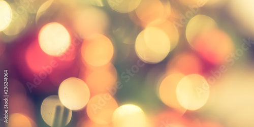 Christmas bokeh blur background with blurry x’mas tree party night light decoration ornate in warm red green gold color for holiday greeting card backdrop