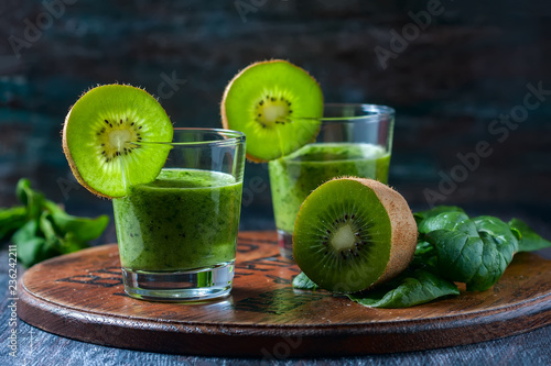 Healthy green smoothie from spinach and kiwi on a wooden table