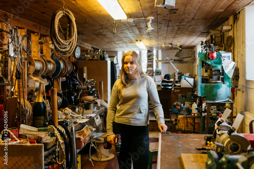 Teenage girl holding a hand drill in rope maker shop photo