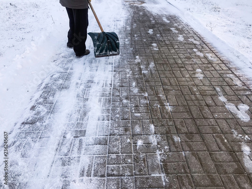 Worker sweep snow from road in winter, Cleaning road from snow storm