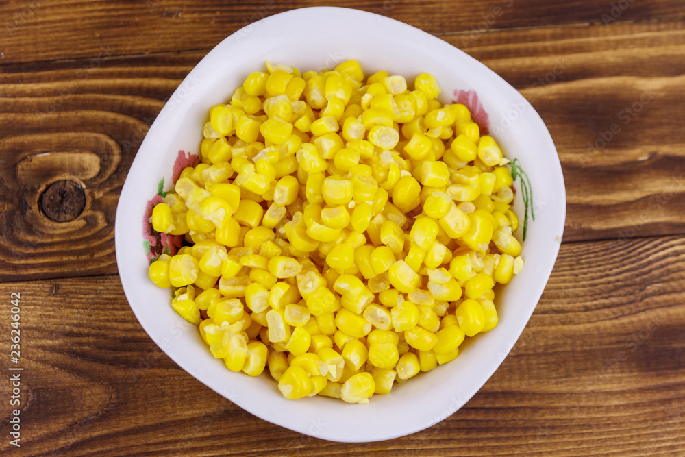 Canned sweet corn in a bowl on wooden table Canned sweet corn in a bowl on wooden table