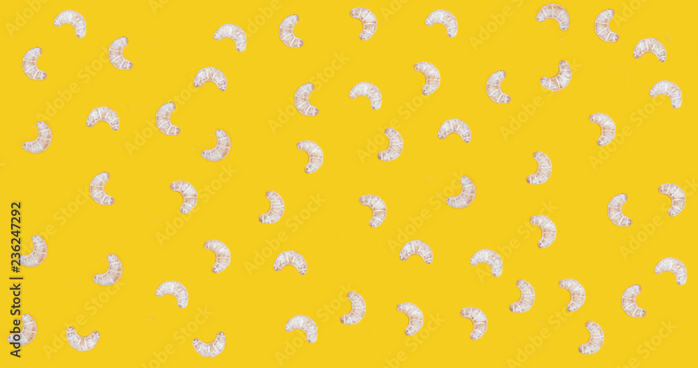Croissant cookies sprinkled with powdered sugar on a yellow background
