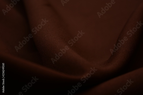 Texture of dark brown fabric closeup. Low key photo. Plexus threads. Clothing industry. Abstract background. Textile waves.
