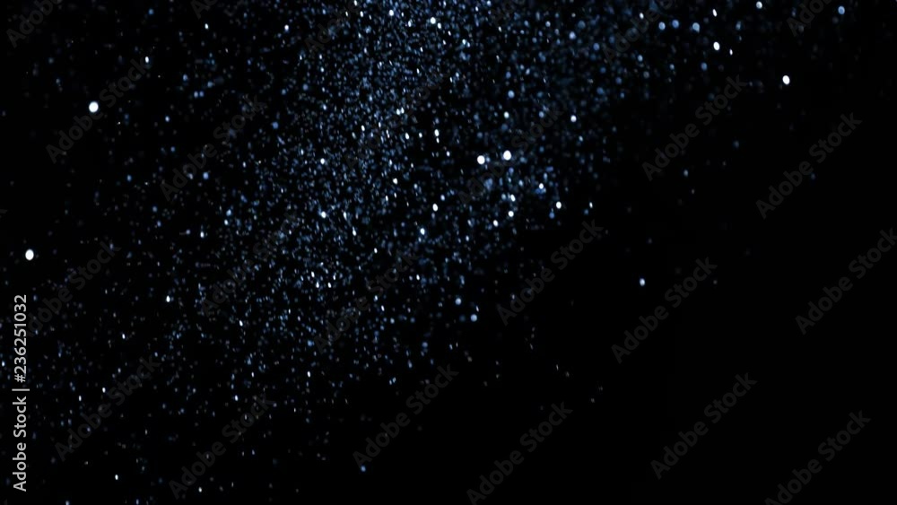 Super slow motion of glittering blue particles on black background. Shallow depth of focus. Filmed on high speed cinema camera, 1000 fps. Super slow motion of glittering blue particles on black background. Shallow depth of focus. Filmed on high speed cinema camera, 1000 fps.